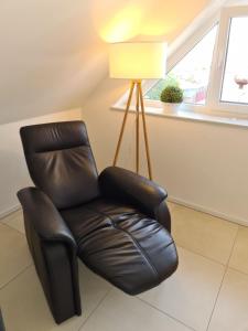 skórzanym rozkładanym krzesłem w pokoju z lampką w obiekcie Ferienwohnung Grachtenhimmel - a86189 w mieście Greetsiel