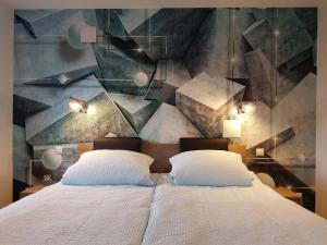 um quarto com uma cama grande e uma pintura na parede em Lindenstuuv em Mittelangeln