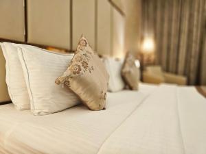 eine Reihe von Kissen auf einem Bett in einem Hotelzimmer in der Unterkunft UVA Meridian Bay Resort & Spa in Kundapura