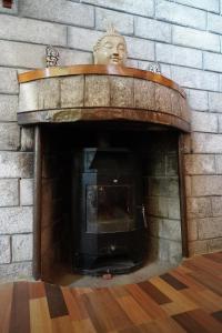 una chimenea de piedra con una cabeza encima en The Vintage Inn by suman cottage, en Manali