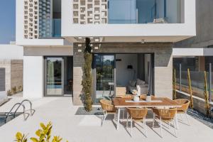 eine Außenterrasse mit einem Holztisch und Stühlen in der Unterkunft Oasis Villa 6 in Klorakas