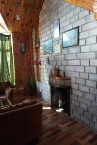 sala de estar con pared de ladrillo y chimenea en The Vintage Inn by suman cottage, en Manali