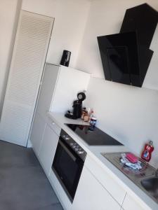 a white kitchen with a stove and a microwave at Villa Mariensiel 1OG li in Sande