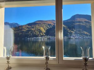 una finestra con vista sull'acqua e sulle montagne di A14Apt Rosa Blu a Brusino Arsizio