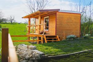 uma pequena cabina de madeira num campo com uma cerca em Maringotka em Třebívlice