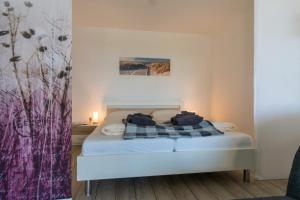 a bedroom with a bed with a plaid blanket at Fewo Sandkueste in Heiligenhafen