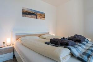 a bedroom with a large bed with towels on it at Fewo Sandkueste in Heiligenhafen
