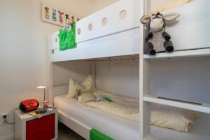 a white bunk bed with a cow toy on it at Fewo Sandkueste in Heiligenhafen