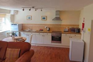 uma cozinha com um sofá e uma mesa num quarto em Underhill Holidays - Underhill Holiday Cottage em Whitby