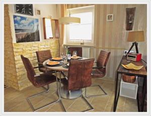 ein Esszimmer mit einem Tisch und Stühlen in der Unterkunft FERIENWOHNUNG DEICHWIESE WESTERLAND-SYLT 4 ZimmerTerrasseGarten3 Schlafzimmer in Süderende