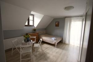 1 dormitorio con 1 cama, mesa y sillas en Pokoje Nadrzeczna 45, en Kazimierz Dolny