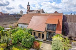 an old house with an orange roof in a city at Loft Im Künstlerhaus in Riegel