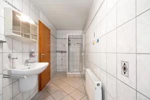 a white bathroom with a sink and a shower at Am Tivoli in Hermeskeil