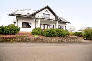 a white house with a solar roof on a stone wall at Am Tivoli in Hermeskeil