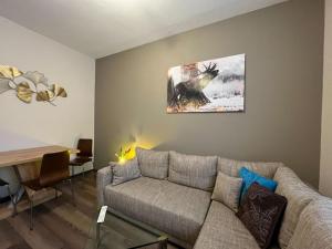 una sala de estar con sofá y una pintura en la pared en 3144 Ferien am SCHLOSS WALD Ap RAPHAEL, en Wald