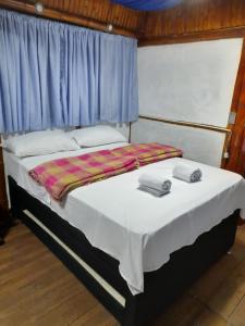 a bed with two towels on it in a room at Cabin in the Mountains - Chalet in Ibagué