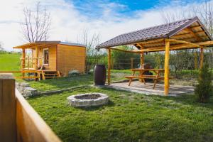 eine Holzhütte mit einem Picknicktisch im Hof in der Unterkunft Maringotka in Třebívlice