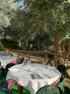 zwei Tische mit Tellern und Weingläsern darauf in der Unterkunft Agriturismo Le Grottelle in SantʼAgata sui Due Golfi