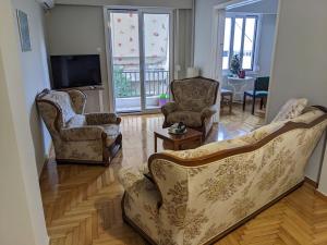 a living room with two chairs and a television at Harbor View Haven in Piraeus