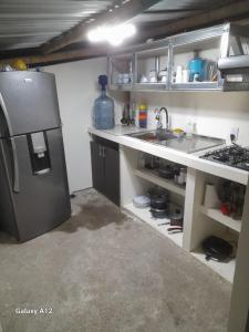een keuken met een koelkast en een wastafel bij Cabin in the Mountains - Chalet in Ibagué