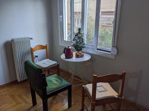 a room with a table with a christmas tree and chairs at Harbor View Haven in Piraeus