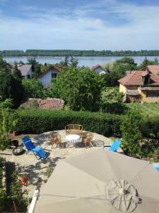 een patio met een tafel en stoelen en een parasol bij Apartmani Jugovo Vazdušna banja - rodjendani za decu in Udovice