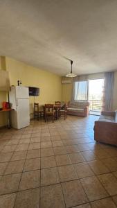 een keuken en een woonkamer met een koelkast en een tafel bij Big Apartment by the Adriatic Sea in Durrës