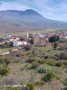 una piccola cittadina in un campo con una montagna sullo sfondo di دار الضيافه امال a Tétouan