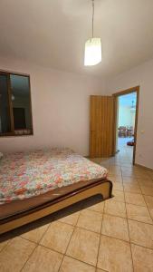 een slaapkamer met een bed op een tegelvloer bij Big Apartment by the Adriatic Sea in Durrës