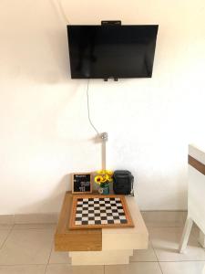 ein Schachbrett auf einem Tisch mit einem TV an der Wand in der Unterkunft Acogedor Apartamento 2 alcobas cerca al mar in Puerto Salgar
