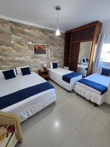 a bedroom with two beds and a brick wall at Hotel Park Stella Mares in Salvador