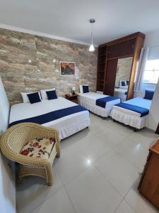 een hotelkamer met 2 bedden en een stoel bij Hotel Park Stella Mares in Salvador