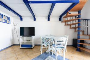 Zimmer mit einem Tisch, einem TV und einer Treppe in der Unterkunft [Sorrento Coast] - Suite 10 Meters From The Sea in Meta