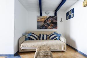 ein Sofa in einem Zimmer mit einem Gemälde an der Wand in der Unterkunft [Sorrento Coast] - Suite 10 Meters From The Sea in Meta