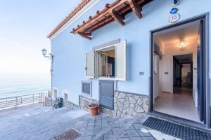 ein blaues Haus mit Tür und Meer in der Unterkunft [Sorrento Coast] - Suite 10 Meters From The Sea in Meta