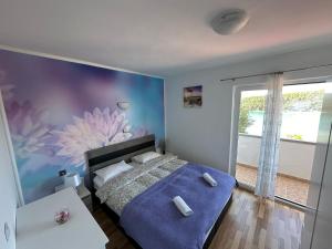 Kampor的住宿－Family Deluxe Apartment Mirjana，卧室配有一张墙壁上涂有鲜花的床。