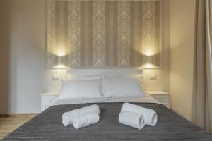 1 dormitorio con 1 cama con 2 toallas en Mirabilia House Termini, en Roma