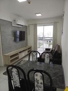 uma sala de estar com uma mesa e cadeiras e uma televisão em Flat Smart Residence em Teresina