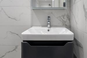 a white sink in a bathroom with a mirror at Indigo Heaven at Hemel in Hemel Hempstead