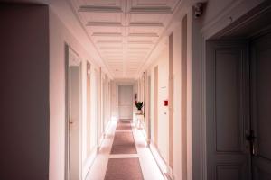 un couloir avec des murs blancs et un plafond dans l'établissement Hotel Bellevue, à Gardone Riviera
