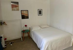 - une chambre avec un lit et une table avec une lampe dans l'établissement Aubervilliers maison de ville près métro 7 by immo kit bnb, à Aubervilliers