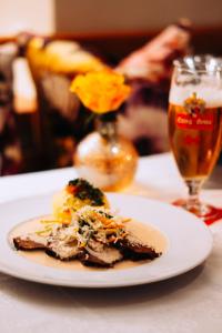 a plate of food on a table with a glass of beer at Bräustüberl Schönbrunn - Hotel & Restaurant in Wunsiedel +48 photos