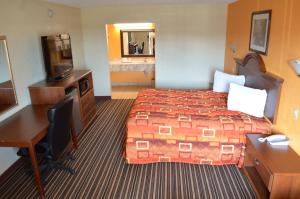 a hotel room with a bed and a desk at Royal Inn Greenville in Greenville