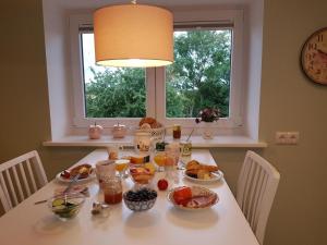 einen Tisch mit Frühstücksspeise darauf mit Fenster in der Unterkunft Haferspieker in Mittelangeln