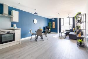 een keuken en een woonkamer met een blauwe muur bij Indigo Heaven at Hemel in Hemel Hempstead