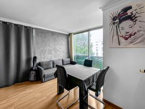 een woonkamer met een tafel en een bank bij Le Lumineux - Proche centre-ville et Atlantis in Saint-Herblain