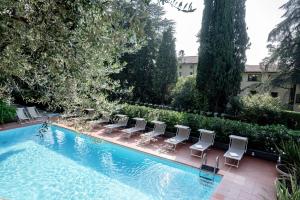 a row of chairs and a swimming pool at Hotel Bellevue in Gardone Riviera