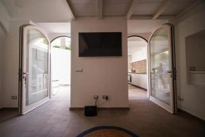 een woonkamer met een flatscreen-tv aan de muur bij Nerano Casa Adelaide in Nerano