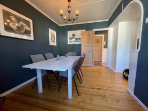 a dining room with a white table and chairs at Large, central and quiet apartment. in Stavanger