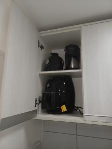 a cupboard with pots and pans sitting in it at Flat Smart Residence in Teresina